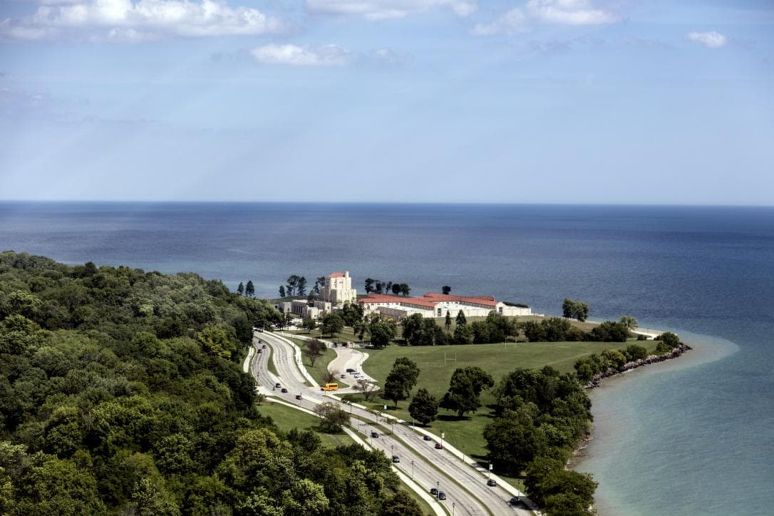 An aerial view of a water-treatment plant on a lake shore, its rectangular basins laid out beside the open water.